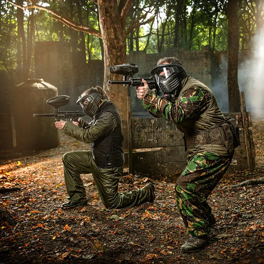 Two paintball players in camouflage gear during a woodland game at Action Sports